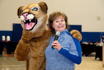 Superintendent Cindy Daniels smiles with the Chino Valley school mascot at the rural arizona school food pantry